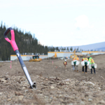 Des travailleurs de la revégétalisation sur le site à Tsē Zūl avec des boîtes de semis.