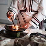 Leena lightning the qulliq, the traditional Inuit oil lamp.