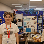 Deux participants devant leur panneau de projet.