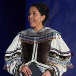 Master of Ceremony Miali Coley-Sudlovenick standing onstage in traditional clothing.
