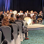 Photo d'une salle remplie de membres de la communauté, de représentants du gouvernement et d'autres alliés écoutant les tambours inuits lors de l'ouverture de la cérémonie de signature.