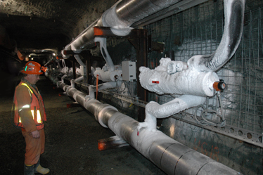 Un mineur inspecte les tuyaux souterrains utilisés pour la méthode des blocs congelés, qui commencent à être recouverts de glace.